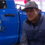 a man being interviewed infront of a blue unlimited freedom truck
